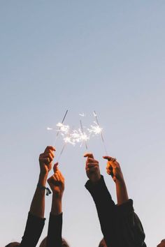 several people are holding sparklers in the air