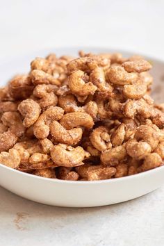 a white bowl filled with nuts on top of a table