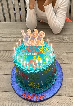 a woman sitting in front of a cake with candles on it