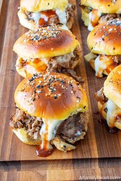 several sliders with meat and cheese on a cutting board