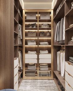 a walk in closet filled with lots of white and brown items on wooden shelves next to a blue chair