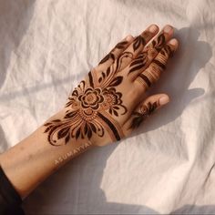 a woman's hand with henna tattoos on it