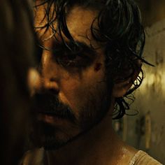 a man with wet hair and beard standing in front of a mirror