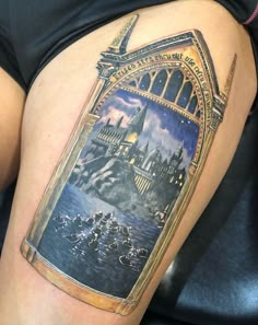 a woman's thigh with a hogwarts castle tattoo on her left side