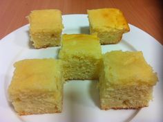 four pieces of yellow cake on a white plate