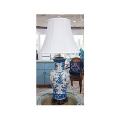 a large blue and white vase sitting on top of a table next to a lamp