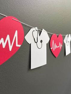 paper cutouts are hanging on a string with hearts and heartbeats attached to it