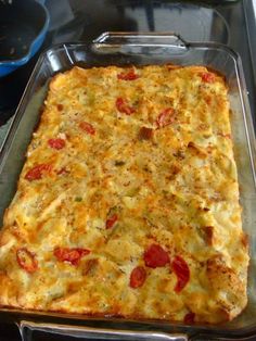 a casserole dish with tomatoes and cheese in it sitting on a stove top