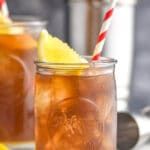 two mason jars filled with iced tea and lemon slices