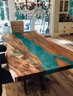 a dining room table made out of wood with blue paint on the top and bottom