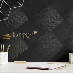 a desk with an arrow on it and the words happy written in gold letters above it