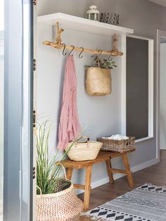 the entryway is decorated with wicker baskets and hanging hooks, along with plants