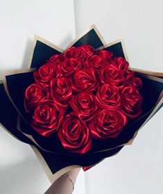 a person holding a bouquet of red roses