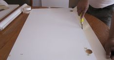 a person is cutting out some paper on a table