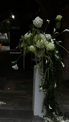 white flowers and greenery are on display outside