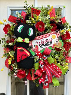 a wreath with a black cat and watermelon on it that says welcome summer