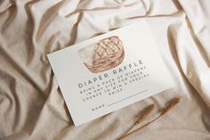 a piece of paper that reads diaper raffle on top of a bed sheet