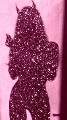 the silhouette of a woman with horns on her head is shown against a pink background