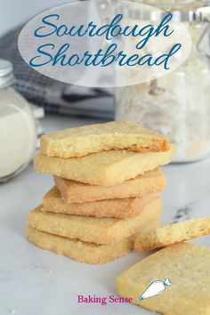 a stack of shortbread cookies sitting on top of a counter next to a jar of sugar