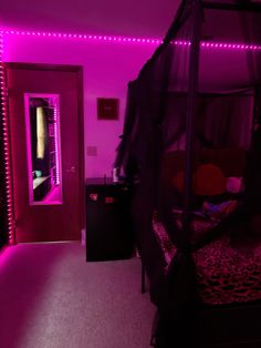 a bedroom with pink lights and a canopy bed