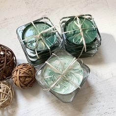 four square candles tied with twine and sitting on a table next to each other