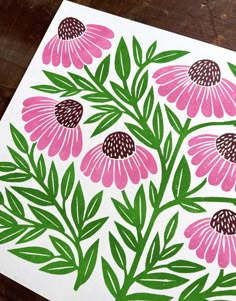 a pink flower with green leaves on a white paper cut out to look like flowers