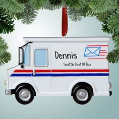 a white postal truck ornament hanging from a christmas tree