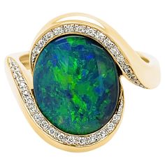 The ‘Gabriella’ opal engagement ring features a gracefully elegant and unique black opal (3.35ct) sourced from Lightning Ridge opal mines in NSW, Australia. The rare play-of-colour in this black opal is absolutely magnificent. Masterfully crafted in 18 karats yellow gold and surrounded by the beauty of dazzling diamonds, this opal ring is bound to receive a Yes to your proposal. Designed by Renata Bernard for your loved one. This Australian black opal ring is a limited edition of one. The gemsto Opal Diamond Engagement Ring, Classic Diamond Ring, Australian Opal Ring, Australian Black Opal, Contemporary Engagement Rings, Black Opal Ring, Opal Engagement Ring, Lightning Ridge Opal, Precious Opal