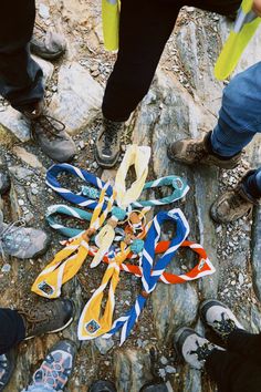 several pairs of shoes are on the ground with ribbons tied to them and people standing around