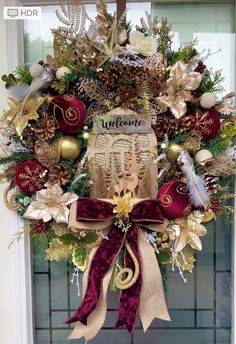 a christmas wreath on the front door decorated with gold, red and white ornaments that spell out someone's name