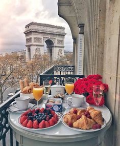 breakfast is served on an outdoor balcony overlooking the eiffel tower