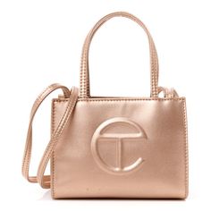 This is an authentic TELFAR Metallic Vegan Leather Small Shopping Bag in Copper.This is a tote crafted of synthetic leather in copper with the iconic raised Telfar logo at the front. The shoulder bag has short top handles, and one long shoulder strap. The top secures with a magnet snap and opens toa copper fabric lined interior. Telfar Logo, Copper Fabric, Dior Jewelry, Oversized Bag, Versace Bags, Wallet Fashion, Hobo Handbags, Luxury Accessories, Synthetic Leather