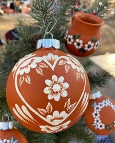 an orange ornament hanging from a tree with white flowers and leaves on it