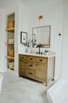 a bathroom vanity with two sinks and mirrors on the wall, along with other items