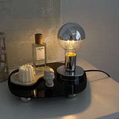 a table with a lamp and soap dispenser sitting on top of it