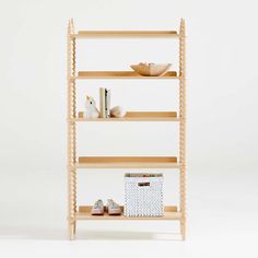 three wooden shelves with baskets and books on them, one shelf has a basket next to it