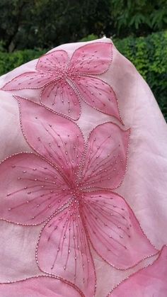 a pink hat with flowers embroidered on it