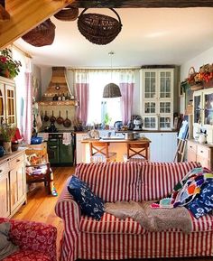 a living room filled with furniture next to a kitchen