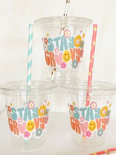 four plastic cups with straws in them on a table