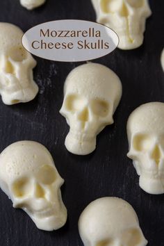 there are many small white skulls on the black surface with a sign that says mozzarella cheese skulls