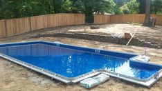 an empty swimming pool in the middle of a yard with no grass or rocks around it