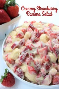 strawberry banana salad in a white bowl with strawberries on the side and text overlay reading creamy strawberry banana salad