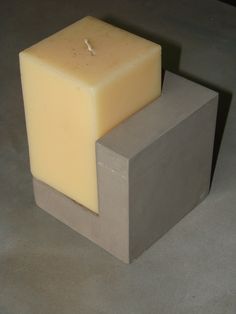 a block of soap sitting on top of a cement block next to a candle holder