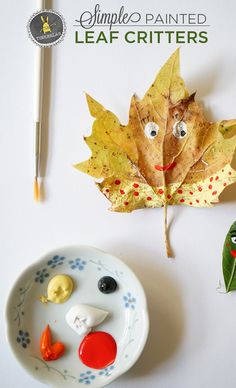 a leaf with eyes, nose and mouth is next to a plate with other items on it