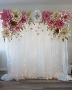 a white curtain with flowers on it in front of a light - up wall and floor