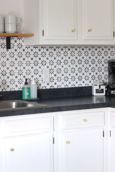 a kitchen with white cabinets and black counter tops