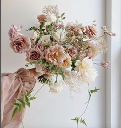 a vase filled with lots of flowers next to a window