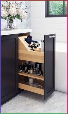 an open cabinet in a bathroom next to a bathtub with flowers on the window sill