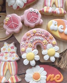 some decorated cookies are sitting on a wooden board with flowers and other decorations around them