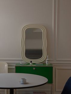 a white table with a mirror on it and two chairs in front of the table